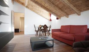 een woonkamer met een rode bank en een tafel bij CanguroProperties - Al Mas 1 in Cojana