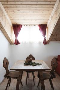 een tafel en stoelen in een kamer met een raam bij CanguroProperties - Al Mas 1 in Cojana