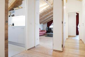 een keuken en een woonkamer met witte muren en houten vloeren bij CanguroProperties - Al Mas 1 in Cojana