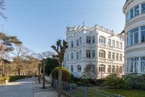 a white building with a tree in front of it at Villa Elfeld Appartment 702 in Binz