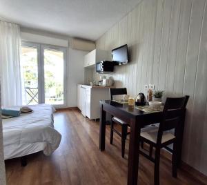 a room with a bed and a table and a kitchen at SAINT-FLORENT Studio 2 pers PISCINE FLO139 in Saint-Florent