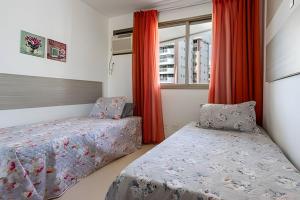 尼泰罗伊Suite, 2quartos, cozinha completa, varandão, 2 vagas de garagem的有两张床和一扇窗户的卧室