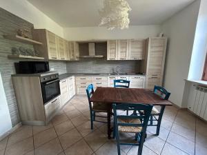 Una cocina con una mesa y sillas de madera. en Grande appartamento in casale ristrutturato, en Santa Domenica