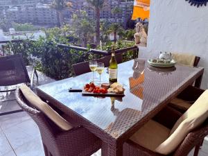 a table with a bottle of wine and a plate of food at Aquamarina Gran Canaria in Los Caideros