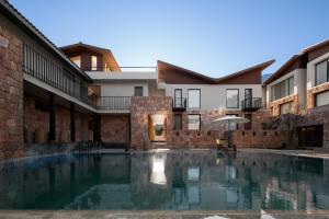 una piscina en el patio de un edificio en Lijiang Snow Mountain stone house, en Lijiang