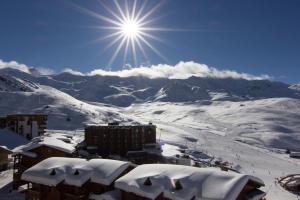 a snow covered mountain with the sun in the sky at Hotel Des 3 Vallées Val Thorens in Val Thorens
