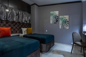 a hotel room with two beds and a chair at Apartamento Tropical Gótico in Cali