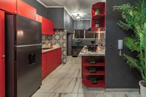 a kitchen with red cabinets and a refrigerator at Apartamento Tropical Gótico in Cali