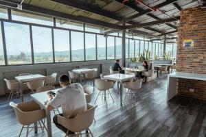 a restaurant with tables and chairs and windows at UMA Suites Chia in Chía