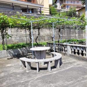 a stone bench with a swing in a park at Lake Soft Blue Mountain Lake Iseo Hospitality in Riva di Solto +28 photos