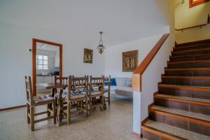 a dining room with a table and chairs and a staircase at Villa in Tossa de Mar (Santa María de Llorell) in Tossa de Mar