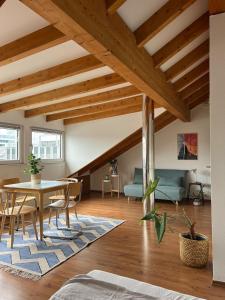 a living room with wooden ceilings and a table and chairs at Cozy loft with a view, central, close to tradefair in Düsseldorf