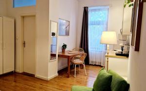 ein Wohnzimmer mit einem Schreibtisch und einem Tisch mit einem Stuhl in der Unterkunft Stylish & Cosy Apartment in Berlin, WiFi in Berlin