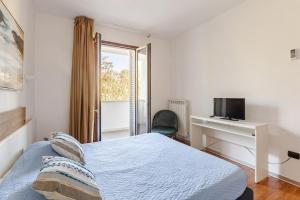 Un dormitorio con una cama y un escritorio con televisión. en Casa da sogno a Porto Cesareo! A due passi dal mare, en Porto Cesareo