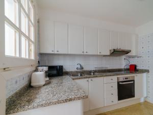 a kitchen with white cabinets and a counter top at Villa in Tossa de Mar (Santa María de Llorell) in Tossa de Mar +12 photos