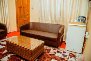 a living room with a brown couch and a table at Beaco Resort in Mbeya +54 photos