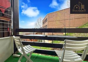 two chairs and a table on a balcony at Studio Cosy - Le Grand-Bornand in Le Grand-Bornand +2 photos