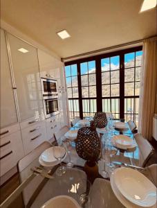 a dining room with a glass table and chairs at CASA PIXURRI en Lanuza compuesta de 5 apartamentos turísticos en casona pirenaica, a 10 minutos de las ESTACIONES de ESQUÍ de FORMIGAL-PANTICOSA in Lanuza