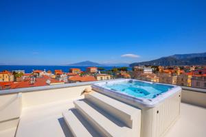 a hot tub on the balcony of a building at AMORE RENTALS - The Square Penthouse in Sorrento