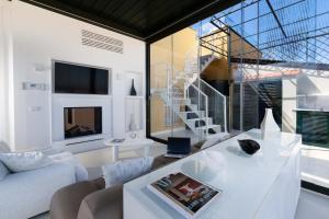 a living room with a white table and a staircase at AMORE RENTALS - The Square Penthouse in Sorrento