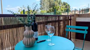 Una mesa con un jarrón, una botella y vasos. en Blue Marine, en Peñíscola