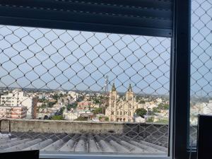 a view of a city through a chain link fence at APTO 1004 Ed PEQUENO PRÍNCIPE in Uruguaiana +3 photos