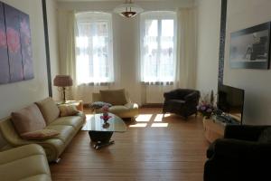 a living room with a couch and chairs and a tv at Große Ferienwohnung 85qm in Havelberg