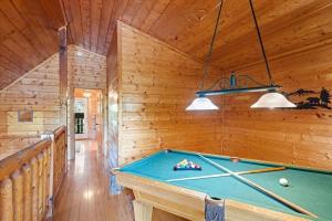 a pool table in a room with wooden walls at Smokies Outlook by Avada Properties in Pigeon Forge