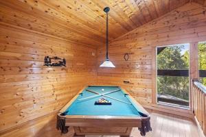 a pool table in a room with wooden walls at Smokies Outlook by Avada Properties in Pigeon Forge