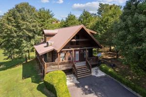 a log cabin with a porch and stairs to it at Smokies Outlook by Avada Properties in Pigeon Forge +17 photos