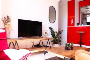 a living room with a television on a wooden table at Le Luz Charmant T3 in Valence