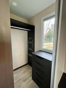 a closet with a black cabinet and a window at Mobil home climatisé Louisiana 4 pers in Sémussac
