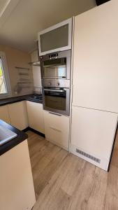 a kitchen with a stainless steel oven and cabinets at Mobil home climatisé Louisiana 4 pers in Sémussac