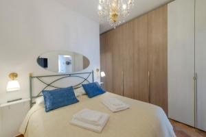 a bedroom with a bed with blue pillows and a mirror at Casa Berenice Positano in Positano