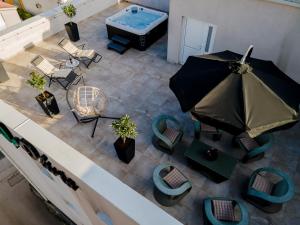 an overhead view of a pool with chairs and an umbrella at Penthouse Olivia Međugorje - Private Jacuzzi in Međugorje