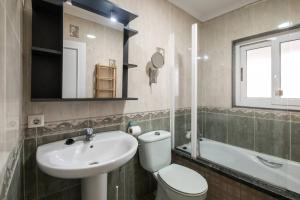 a bathroom with a toilet and a sink and a tub at Durmiendo en el Paraiso in Llanes +33 photos