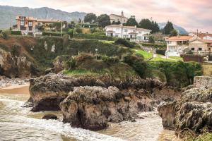 a view of a beach with rocks and houses at Durmiendo en el Paraiso in Llanes