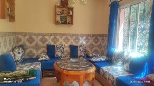 a living room with a blue couch and a table at Maison Touria in Ouzoud