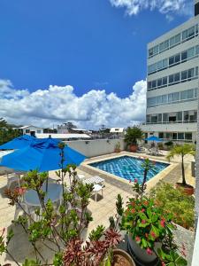 una piscina con sombrilla azul y un edificio en Loft Bahía Fragata, en San Andrés