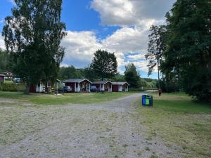 a dirt road in front of a campground with trees at Klämmingsbergsbadets - STUGA GÖSEN in Gnesta +5 photos