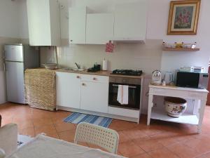 a kitchen with white cabinets and a stove top oven at Casa Vacanza Cascina Ronco relax nella natura vicino a Como e Bellagio in Erba