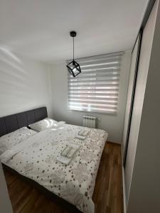 a bedroom with a bed and a window with a bedspread at Apartment ANDI Istocno Sarajevo in Lukavica
