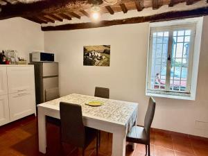 a kitchen with a white table and chairs in a room at Casa Nerina in Chiusdino