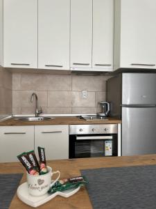 a kitchen with white cabinets and a coffee cup on a table at Apartment ANDI Istocno Sarajevo in Lukavica
