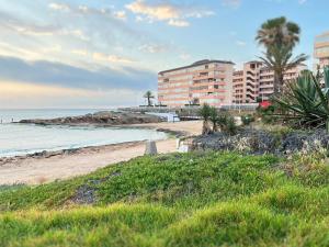 een strand met enkele gebouwen en de oceaan bij The house of secrets in Torrevieja
