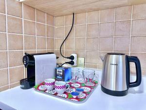 Una bandeja con tazas y una cafetera sobre un mostrador. en Posizione centrale Zambonate, en Bérgamo