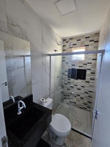 a bathroom with a shower and a toilet and a sink at Home Duplex Serra Negra - casa 8 in Bezerros +29 photos