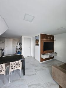 a living room with a television and a table and chairs at Home Duplex Serra Negra - casa 8 in Bezerros