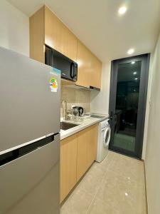 a kitchen with a refrigerator and a washing machine at Regal 40 Srinakarin Apartment in Bangkok +6 photos