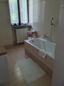 a bathroom with a bath tub and a window at Casa Vacanza Cascina Ronco relax nella natura vicino a Como e Bellagio in Erba +37 photos